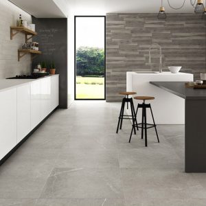 A kitchen with HomeTiles Nival Gris Light Grey Stone Effect tile on the floor'