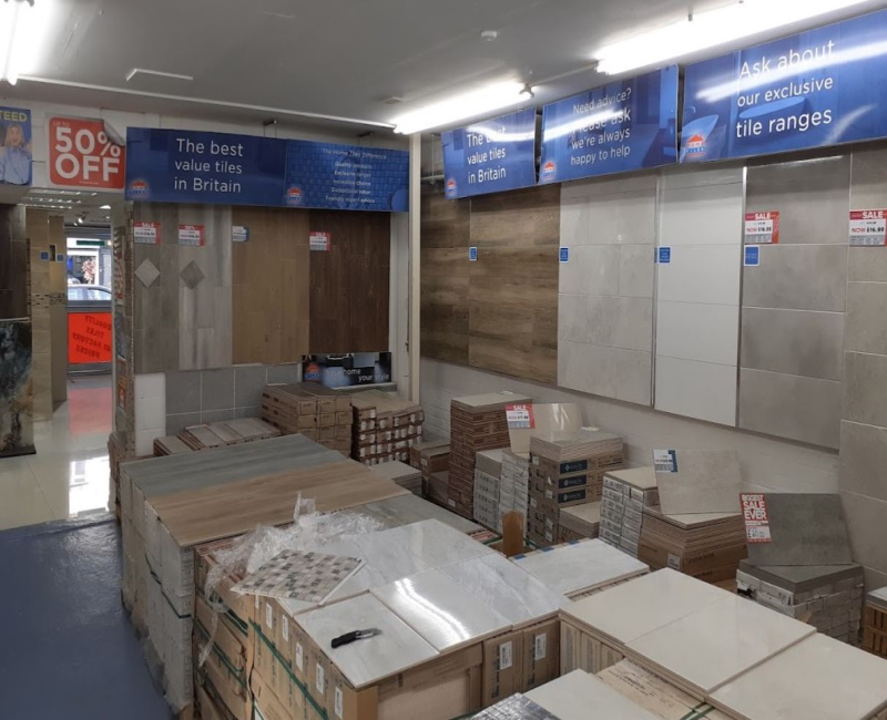 Tile displays mounted on the walls with stock piled on the floor in front of the displays