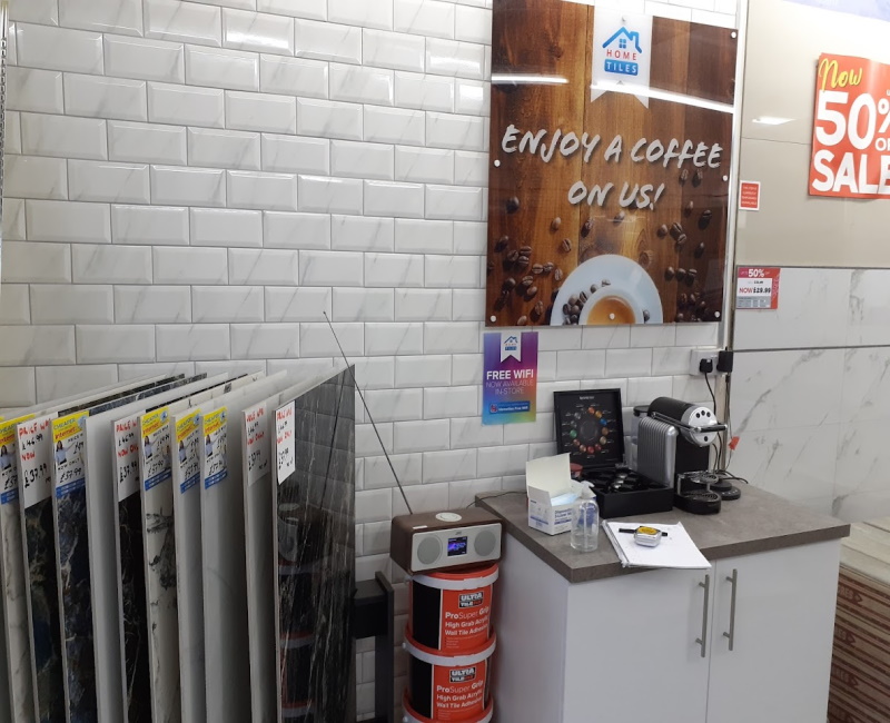 A coffee machine with tile samples in a rack to the left of it
