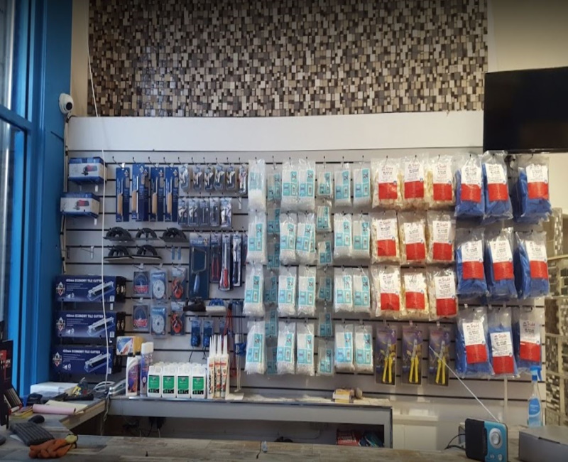 A till area with various tiling products such as spacers and clips hanging out the wall behind the till