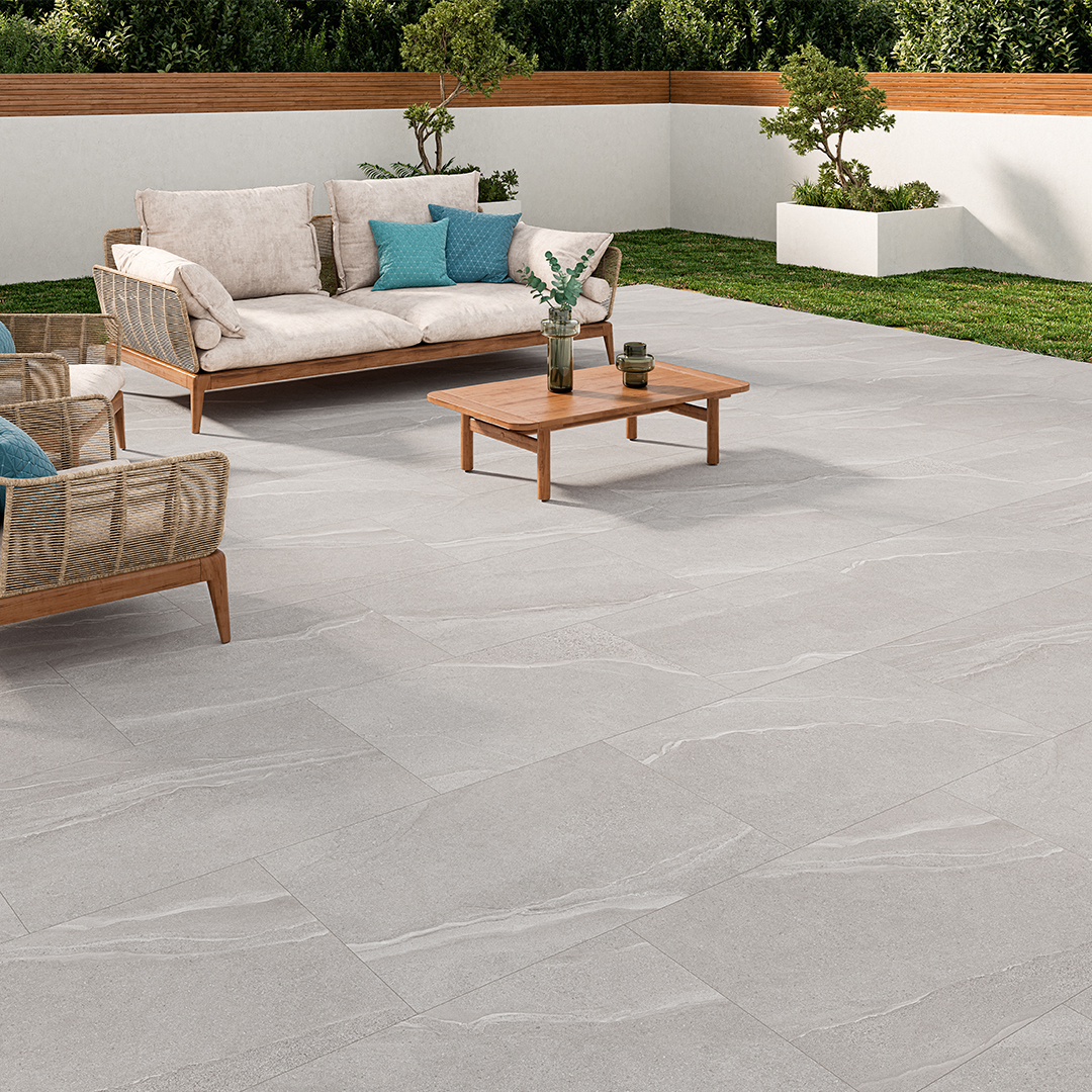 Patio with grey porcelain outdoor tiles. There is a lounge set on the patio.