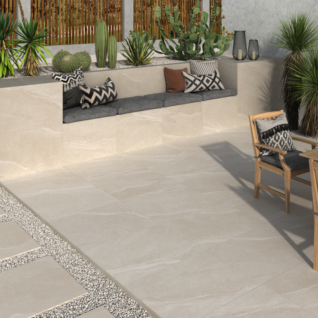 Outdoor porcelain tiles in an ivory colour. There are cacti in the background and a built in wall seat.