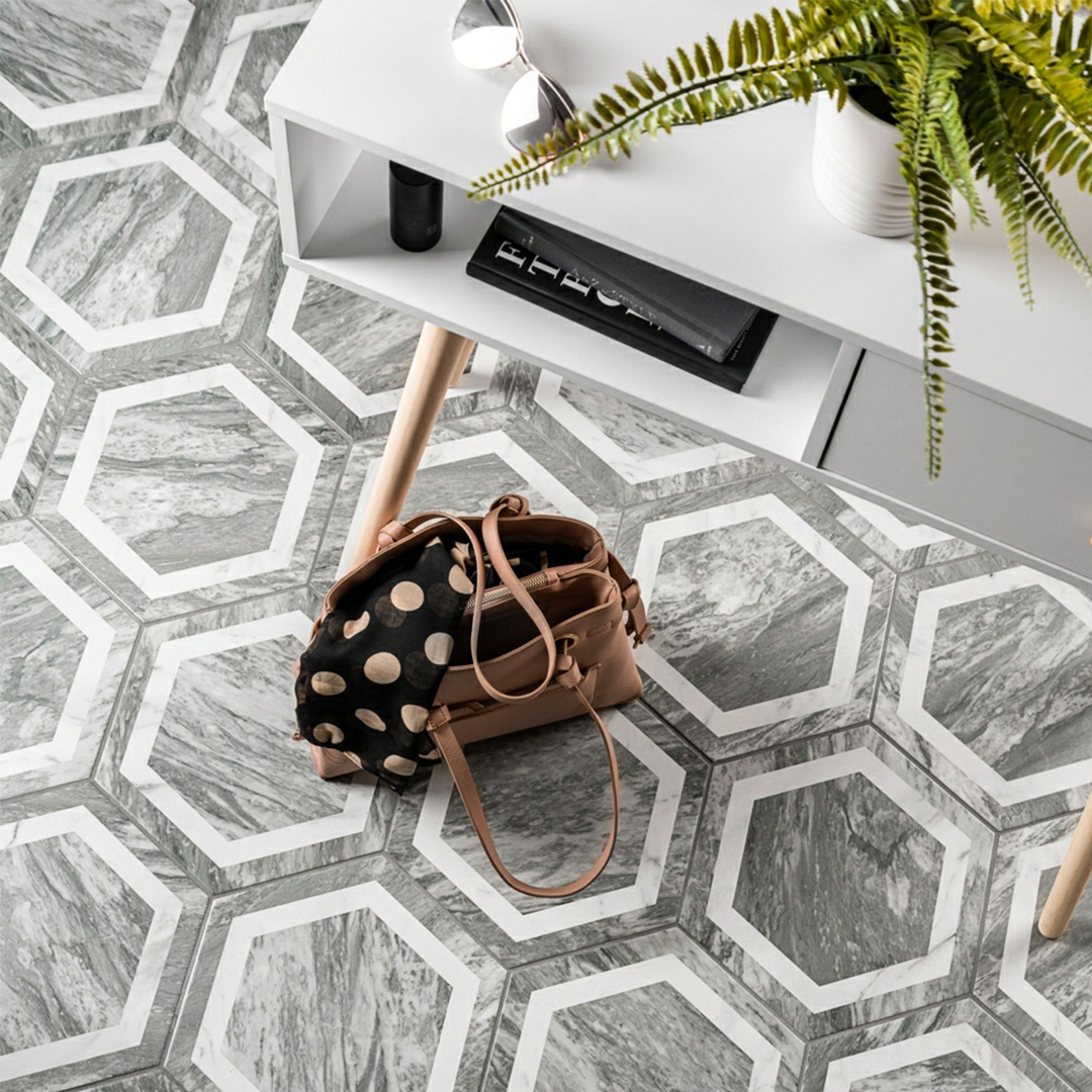 Grey hexagon floor tiles with a console table and handbag on the floor.