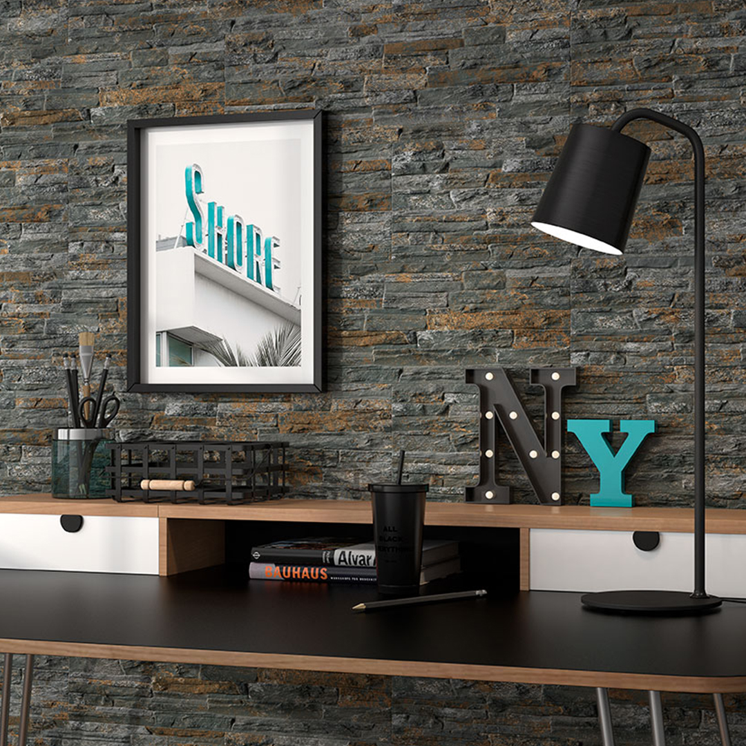 Rustic dark grey wall tiles with a desk and artwork on the wall